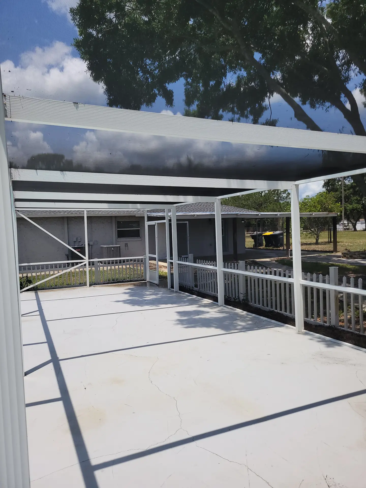Professional pressure washing cleaning a pool and its screen enclosure, removing dirt and grime.